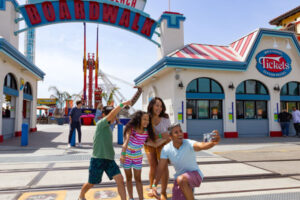 A family enjoying the Santa Cruz Beach Boardwalk, an economical, family-friendly destination