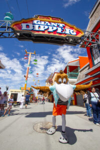 Splash the Pelican posing under the Giant Dipper sign