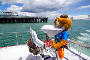 Splash at the helm, waving "hi" to the sea lions.