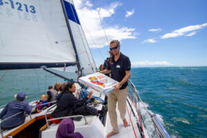 First Mate Cullem handing out pizza slice to passengers.