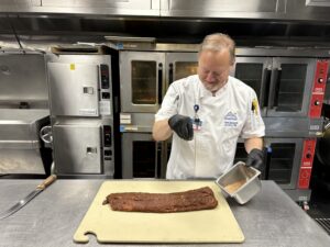 Executive Chef James Squassoni seasoning ribs in the Grove kitchen.