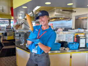 Boardwalk Team Member with corndog at Surf City Grill